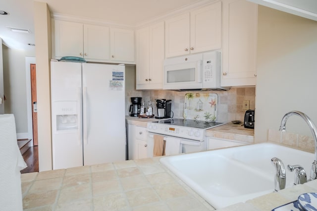 kitchen with tile countertops, sink, white cabinets, and white appliances