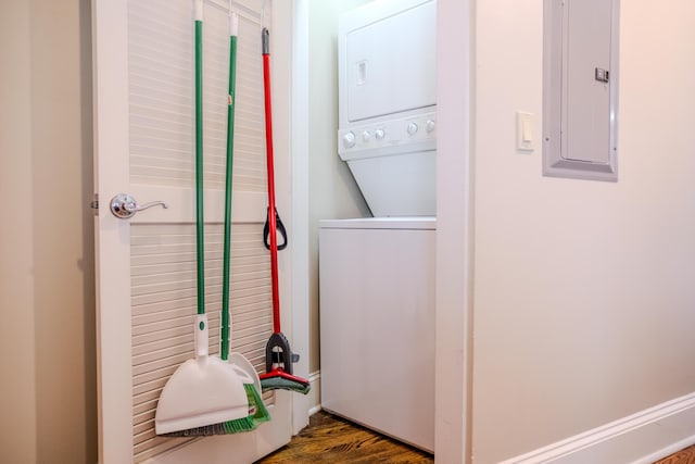 clothes washing area featuring wood-type flooring, stacked washing maching and dryer, and electric panel