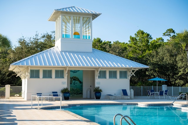 back of house with a community pool and a patio