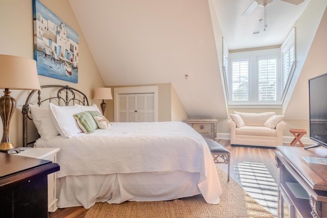 bedroom featuring hardwood / wood-style floors, a closet, vaulted ceiling, and ceiling fan