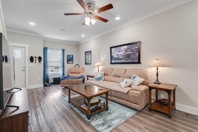 living room featuring hardwood / wood-style flooring, ceiling fan, and ornamental molding