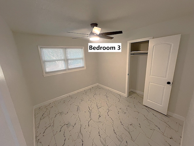 unfurnished bedroom with ceiling fan and a closet