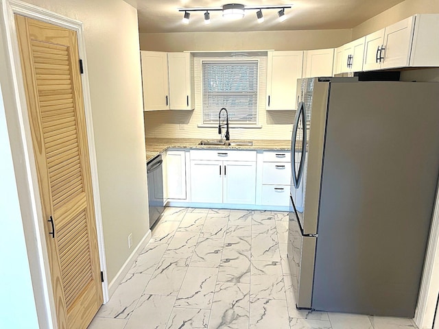 kitchen featuring backsplash, sink, white cabinets, and stainless steel appliances