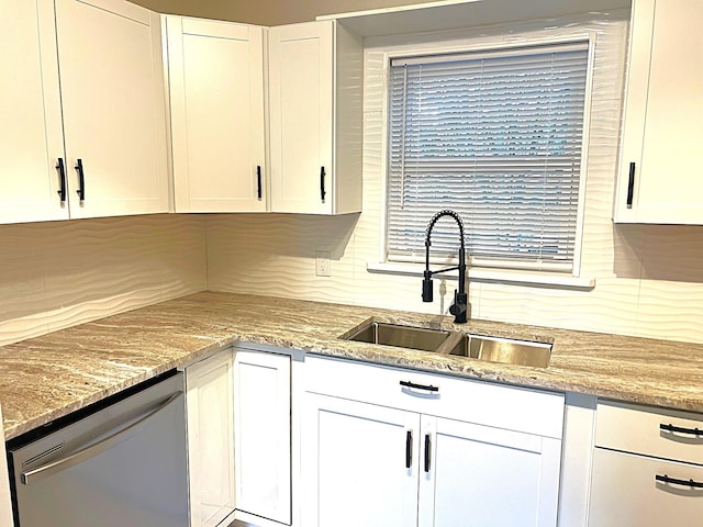 kitchen with decorative backsplash, light stone countertops, stainless steel dishwasher, sink, and white cabinets