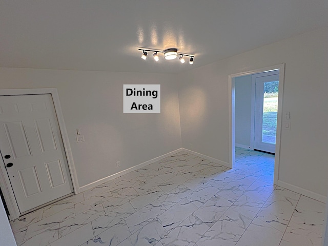 unfurnished dining area featuring rail lighting