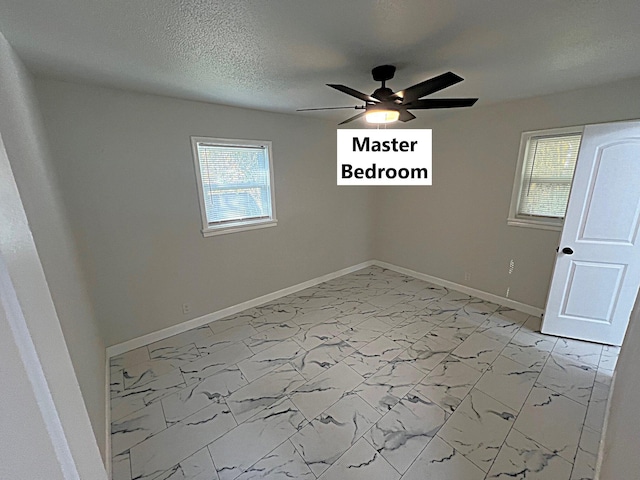 unfurnished room with ceiling fan, a healthy amount of sunlight, and a textured ceiling