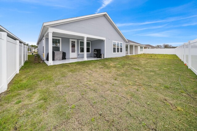 back of house with a lawn and a patio area