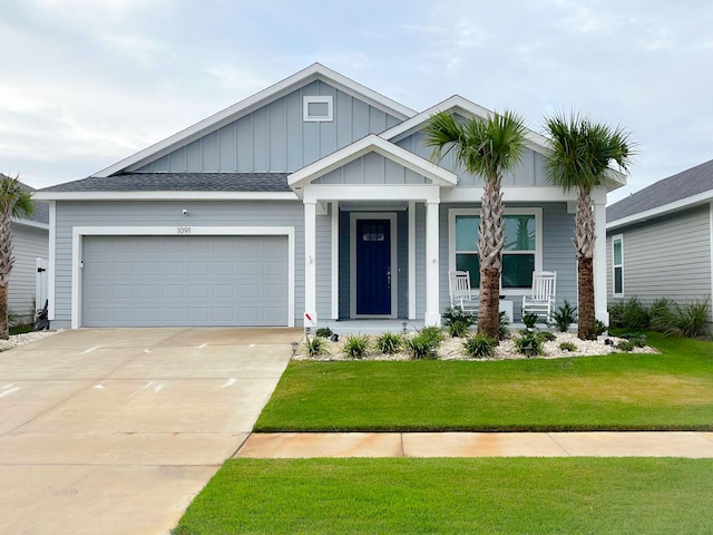 craftsman-style house featuring a garage, a porch, and a front yard