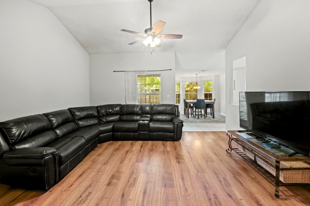 living room featuring ceiling fan, light hardwood / wood-style flooring, and vaulted ceiling