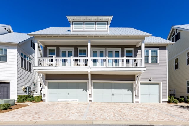 view of front facade with a garage, cooling unit, and a balcony