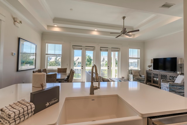 kitchen with a wealth of natural light, ceiling fan, and a tray ceiling