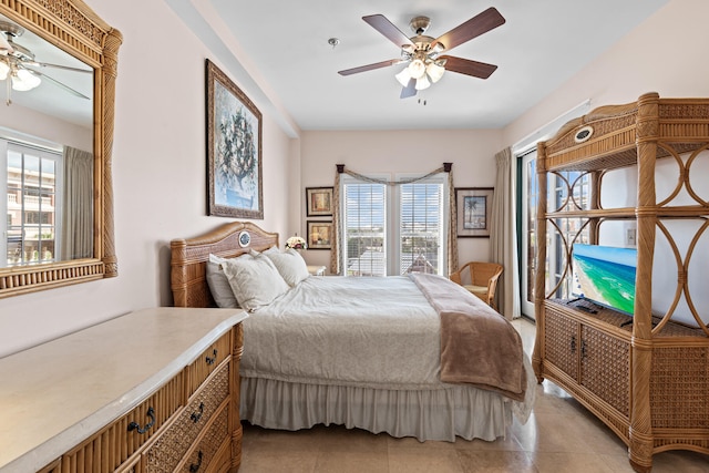 tiled bedroom featuring ceiling fan and multiple windows