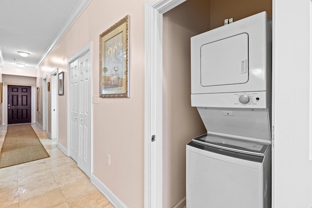 laundry area featuring ornamental molding and stacked washer / dryer