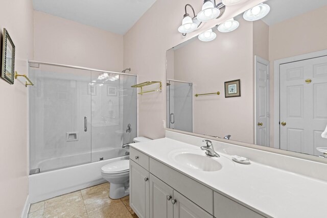 full bathroom with tile patterned floors, vanity, toilet, and shower / bath combination with glass door