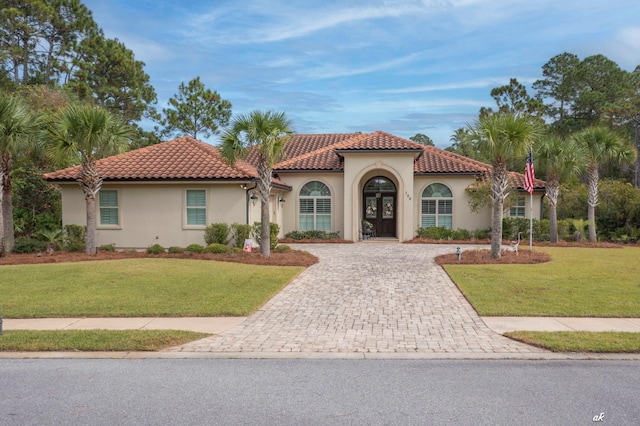 mediterranean / spanish-style home with a front lawn