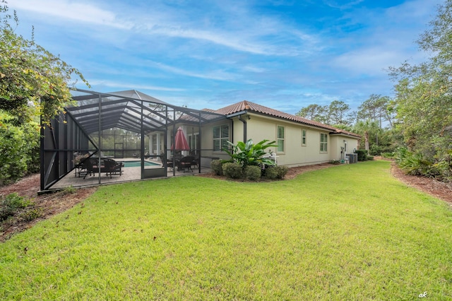 rear view of house featuring a yard, a patio area, central AC unit, and a lanai