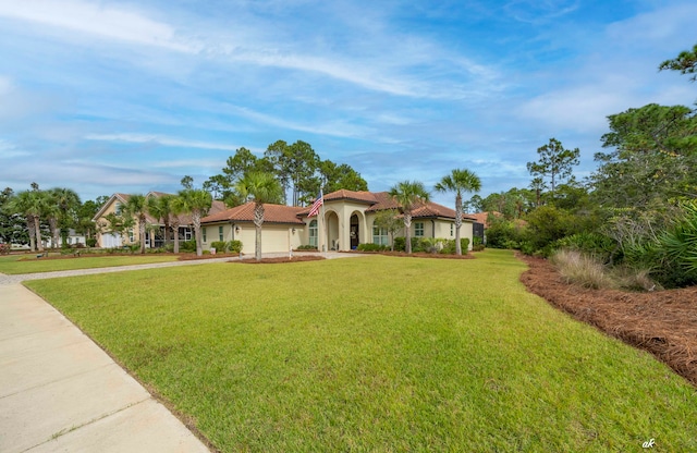 mediterranean / spanish-style house featuring a front lawn and a garage