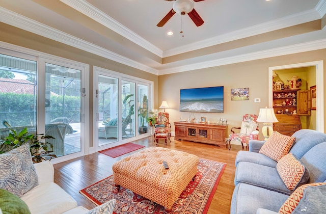 living room with hardwood / wood-style flooring, crown molding, and a healthy amount of sunlight