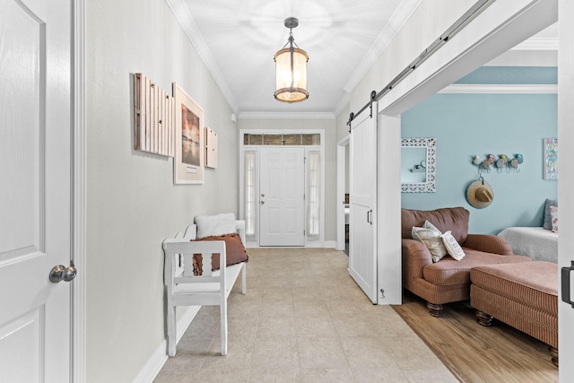 foyer entrance with a barn door, ornamental molding, and light hardwood / wood-style flooring