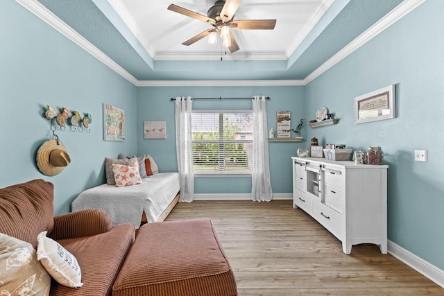 living area featuring a tray ceiling, ceiling fan, light hardwood / wood-style floors, and ornamental molding