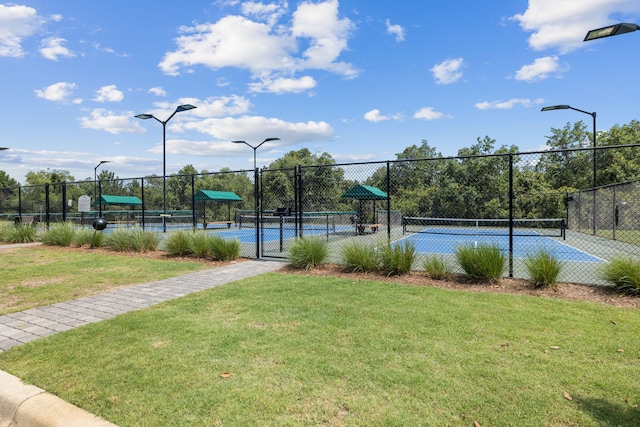 view of sport court with a lawn