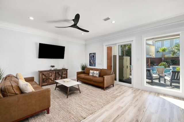 living room featuring ceiling fan, light hardwood / wood-style flooring, and crown molding