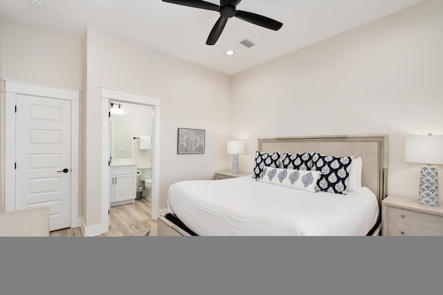 bedroom with ensuite bathroom, ceiling fan, and light hardwood / wood-style flooring