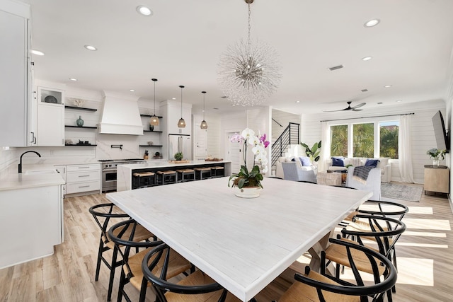 kitchen with custom exhaust hood, a kitchen island, sink, high quality appliances, and white cabinetry