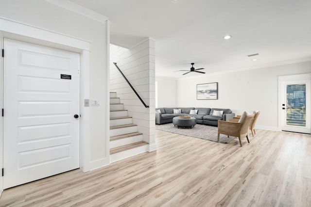 living room with ceiling fan, crown molding, and light hardwood / wood-style floors