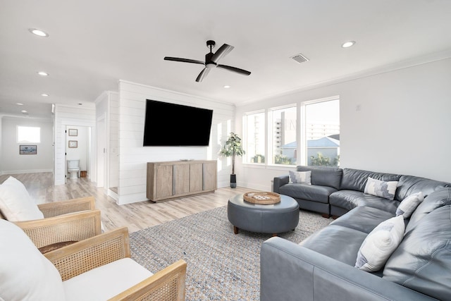 living room with light hardwood / wood-style floors, plenty of natural light, ornamental molding, and ceiling fan