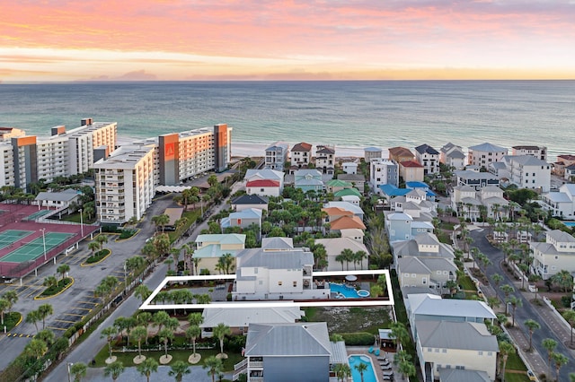 aerial view at dusk featuring a water view