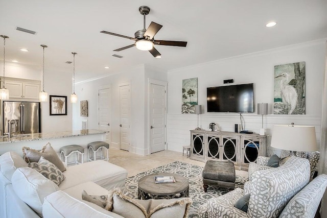 living room with ceiling fan and ornamental molding