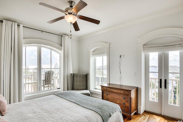 bedroom featuring access to exterior, ceiling fan, french doors, light hardwood / wood-style floors, and ornamental molding