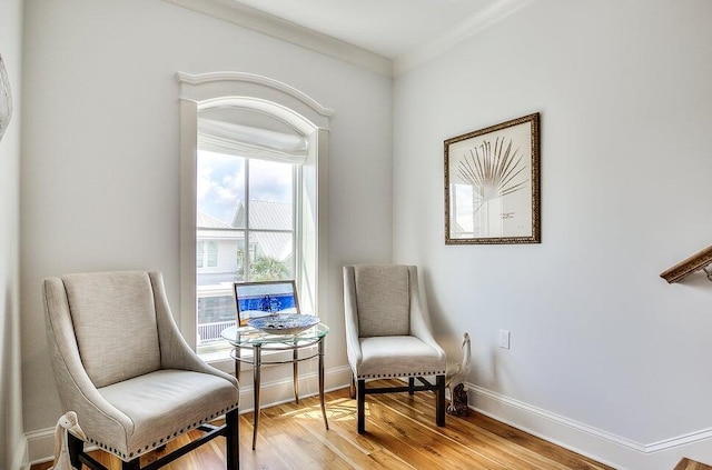 sitting room with light hardwood / wood-style floors and ornamental molding