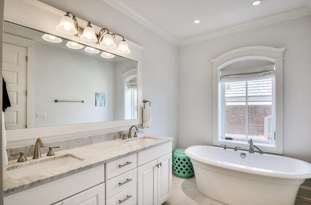 bathroom featuring tile patterned floors, a tub, crown molding, and vanity