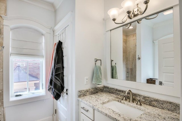 bathroom with vanity, a tile shower, crown molding, and an inviting chandelier