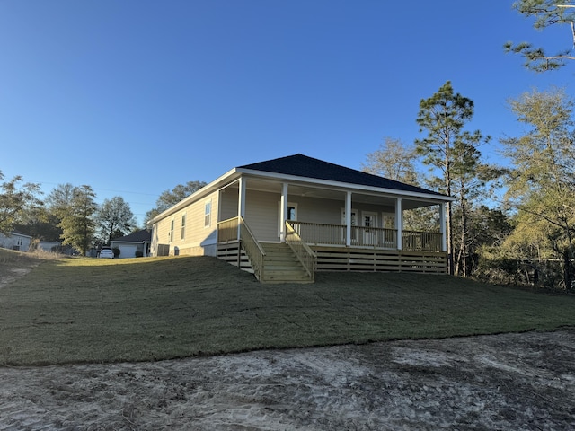 view of front of house with covered porch, a shingled roof, and a front yard