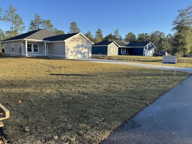 view of front of home with an attached garage, driveway, and a front yard