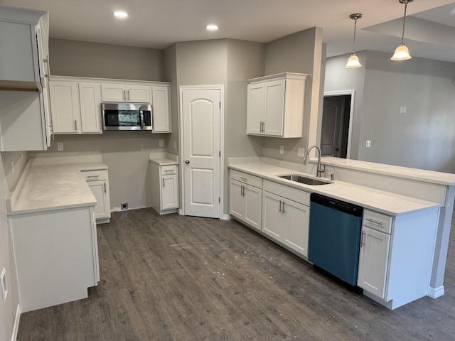 kitchen featuring dishwashing machine, a peninsula, dark wood-type flooring, a sink, and stainless steel microwave