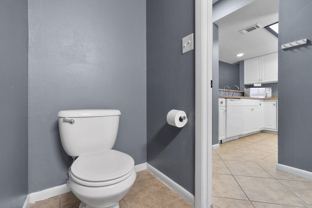 bathroom featuring tile patterned flooring, vanity, and toilet