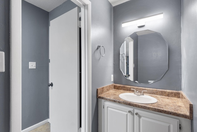 bathroom featuring tile patterned flooring, a textured ceiling, and vanity