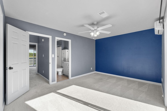 unfurnished bedroom featuring ceiling fan, ensuite bathroom, and light colored carpet