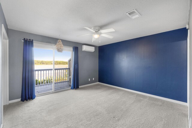 carpeted spare room with a wall mounted air conditioner, a textured ceiling, and ceiling fan