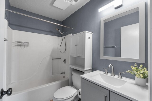 full bathroom with vanity, a textured ceiling, toilet, and washtub / shower combination