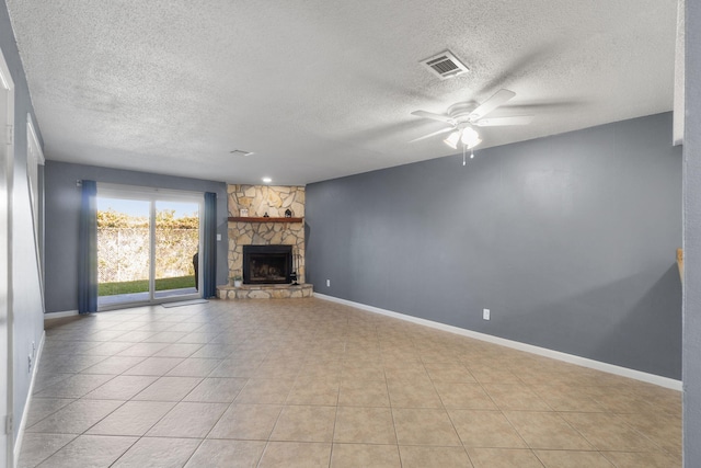 unfurnished living room featuring a fireplace, light tile patterned floors, a textured ceiling, and ceiling fan