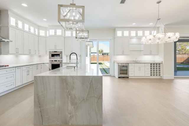 kitchen featuring white cabinetry, pendant lighting, and beverage cooler