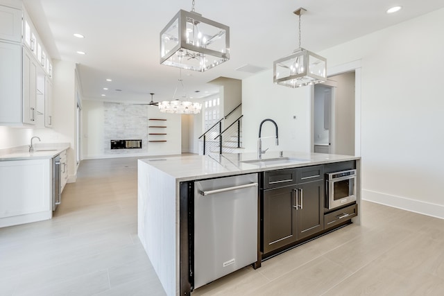 kitchen featuring pendant lighting, sink, stainless steel appliances, white cabinets, and built in shelves