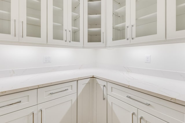 kitchen with light stone counters and white cabinetry