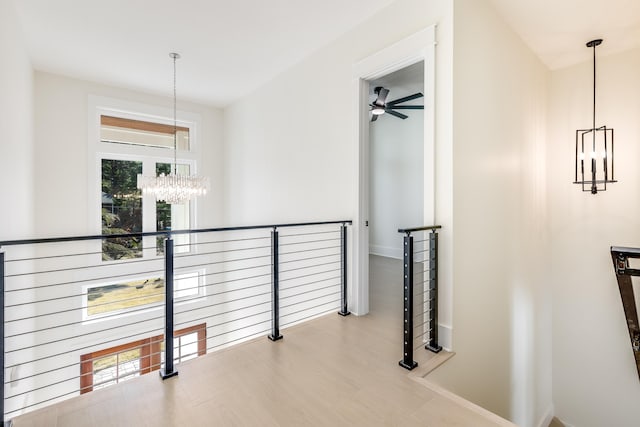 hall featuring light hardwood / wood-style floors and a notable chandelier