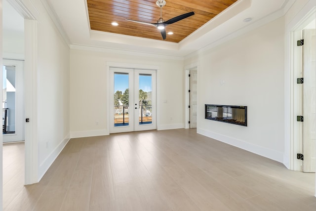 unfurnished living room featuring ceiling fan, wood ceiling, a raised ceiling, light wood-type flooring, and french doors